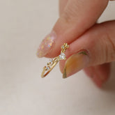 Elegant heart ring for women, featuring intricate design with a sparkling gemstone, held delicately between manicured fingers.